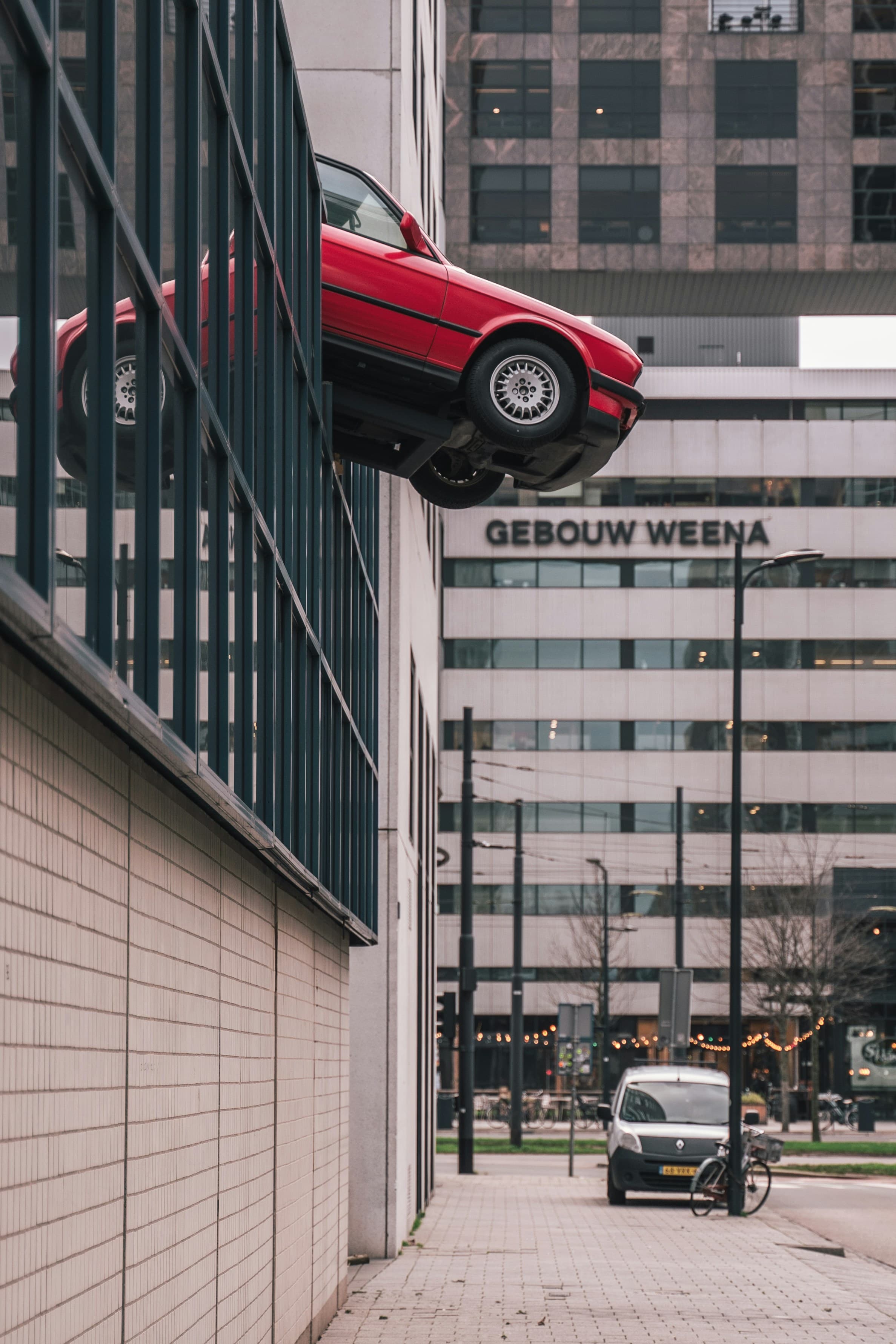 Car with damage hanging on a building