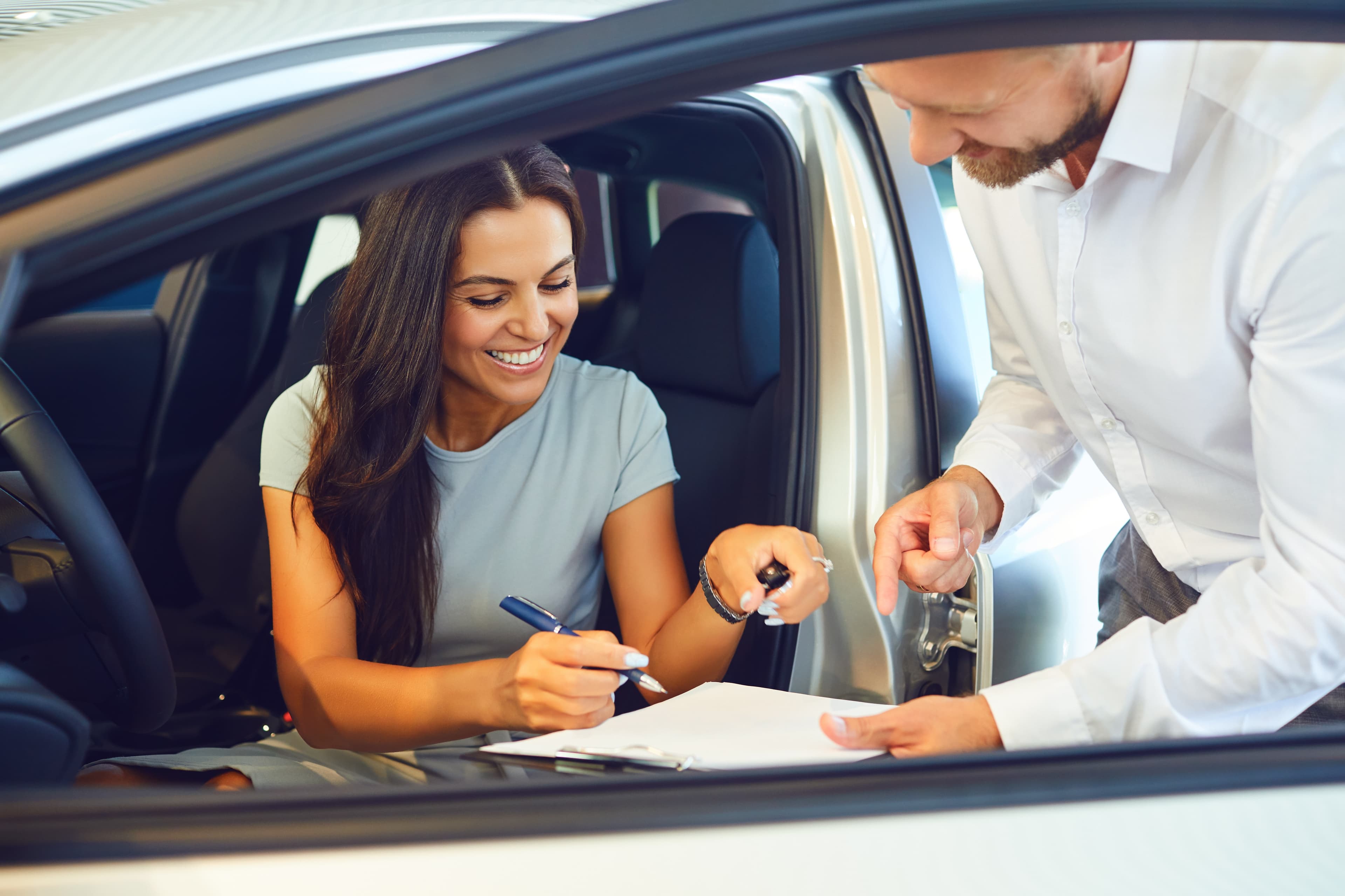 A consumer taking delivery of a car at a dealership